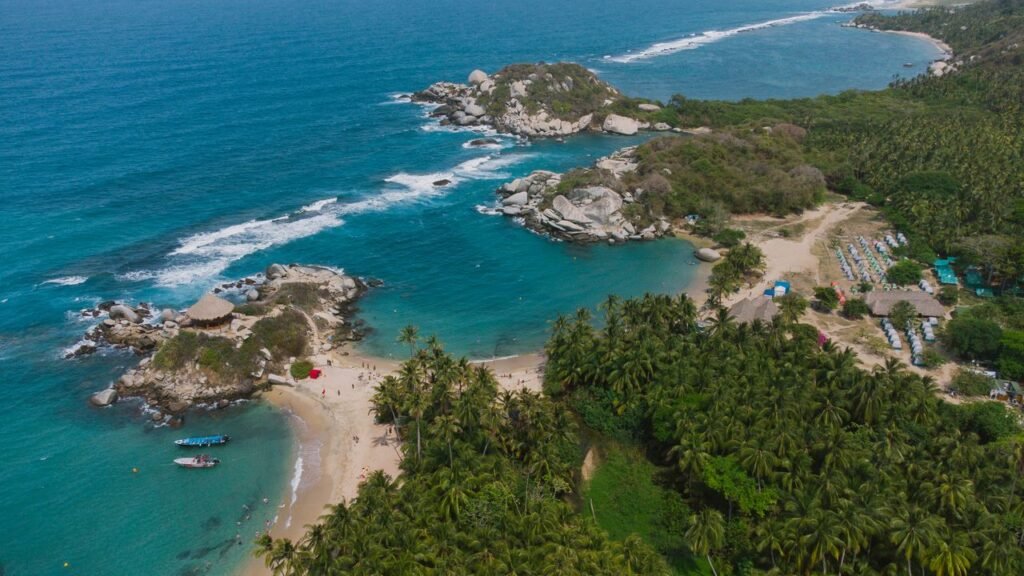 Stunning aerial drone shot of Tayrona National Park's coastline in Colombia, showcasing turquoise waters and lush greenery., Tayrona
