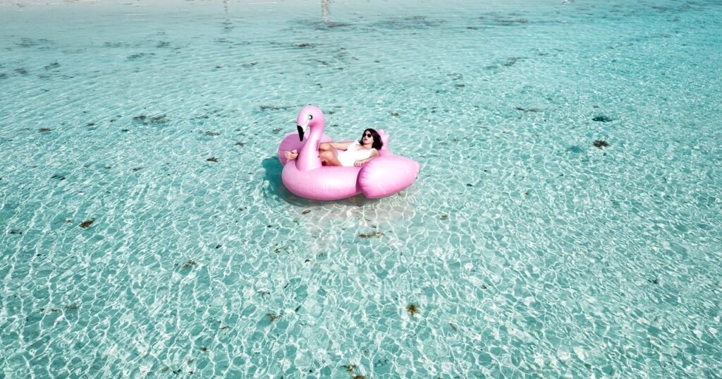A woman enjoying leisure time on a flamingo float in the clear waters of Isla Mujeres., Islas de Rosario