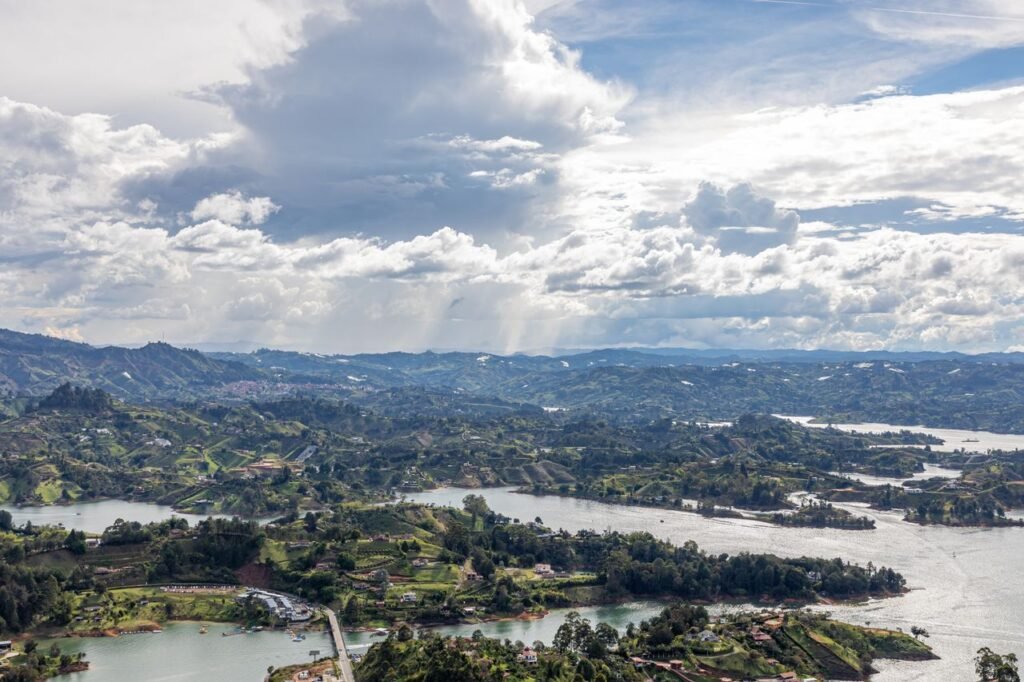 A breathtaking aerial view of the lakes and rolling hills in Guatapé, Antioquia, Colombia, under a dramatic sky., Viajes a Colombia