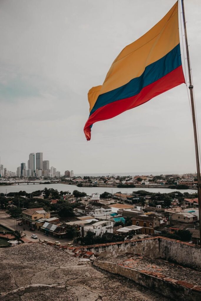 Colombian flag waving over urban landscape with skyline view., Turismo en Colombia
