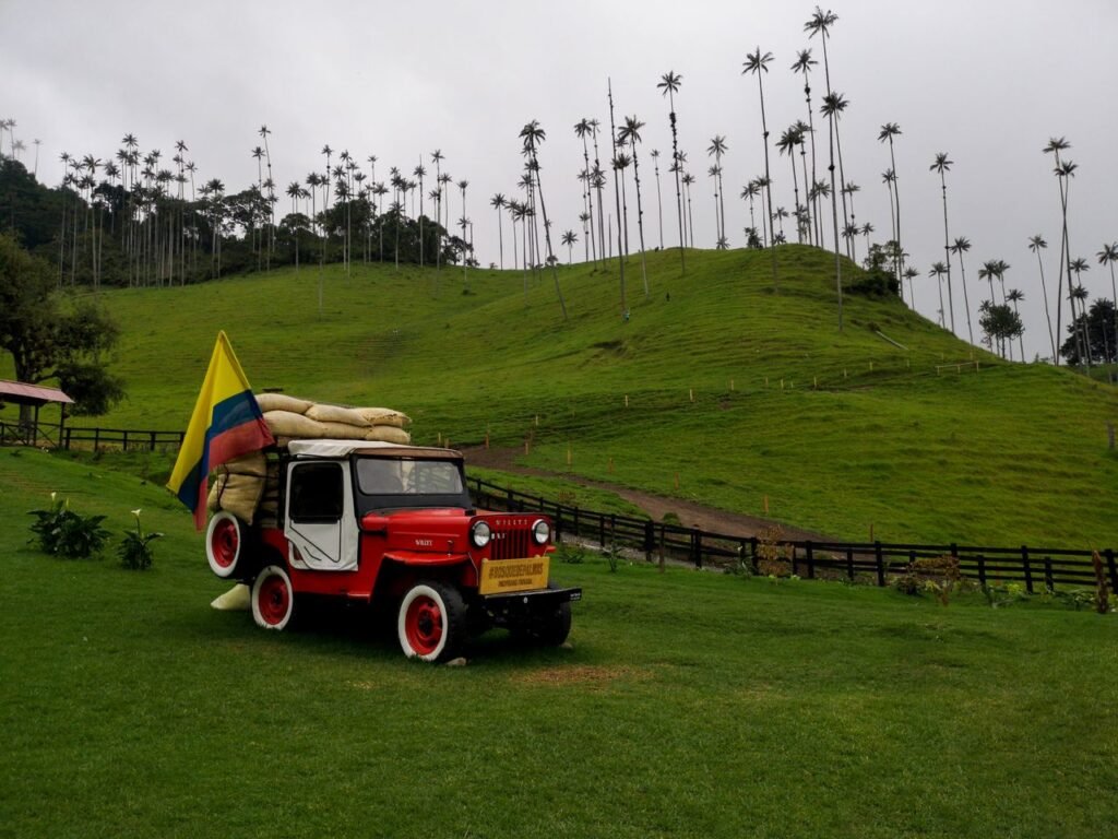 A vintage jeep with Colombian flag in the lush green hills of Salento, Colombia., Quindío