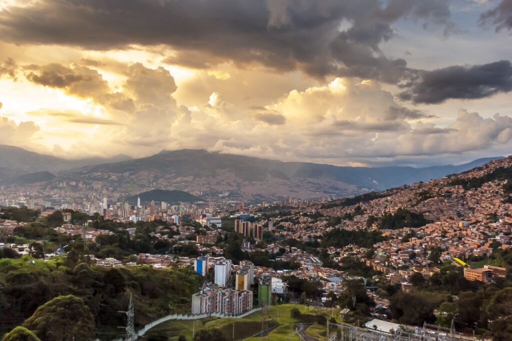 Breathtaking view of Medellin's skyline at sunset with dramatic clouds and vibrant colors., Medellín
