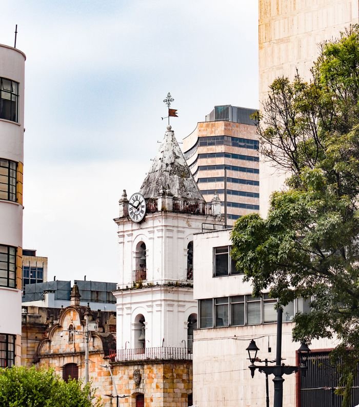 A scenic view of the historic clock tower and modern buildings in Bogotá, Colombia., Turismo en Colombia