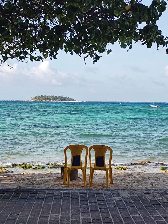 Serene beach scene with two chairs facing turquoise waters of San Andres, Colombia., San Andrés