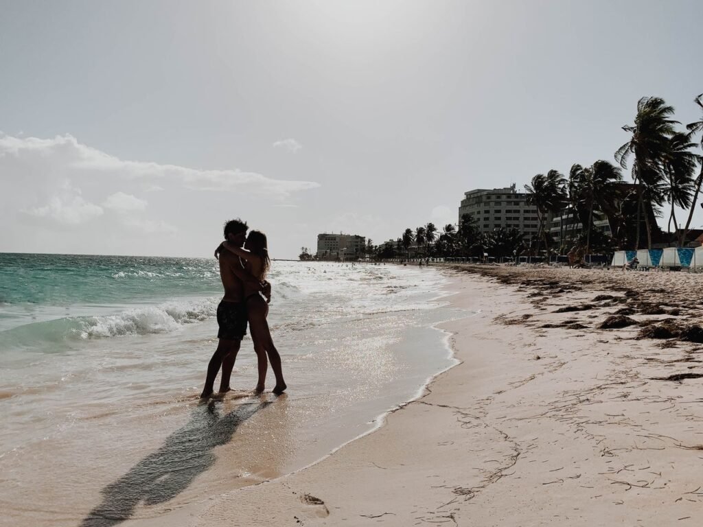 A couple shares a romantic embrace on a picturesque San Andrés beach. Perfect serene getaway., San Andrés