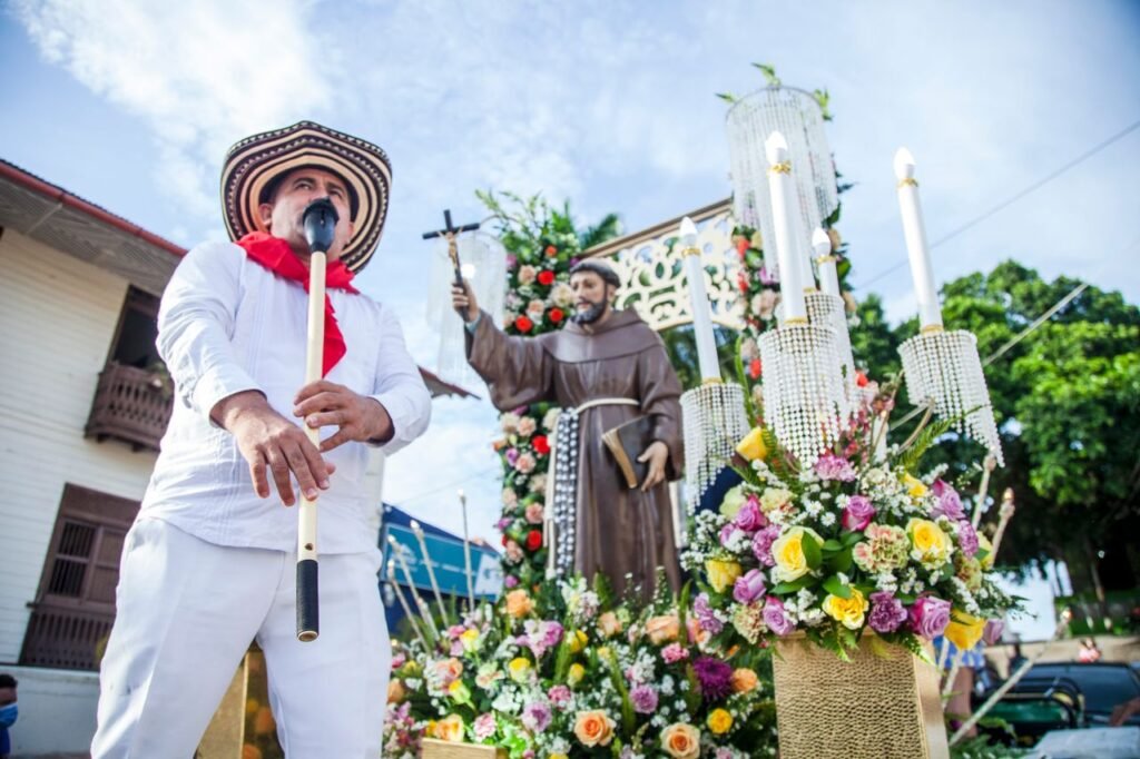 Man in traditional attire leading a colorful religious procession in Ovejas, Colombia., Cartagena