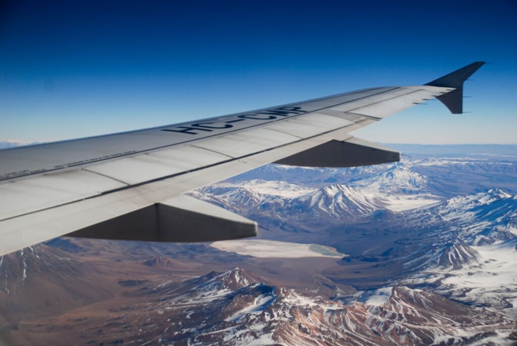 Spectacular aerial view of snow-capped mountains seen from an airplane wing. consejos para conseguir vuelos baratos