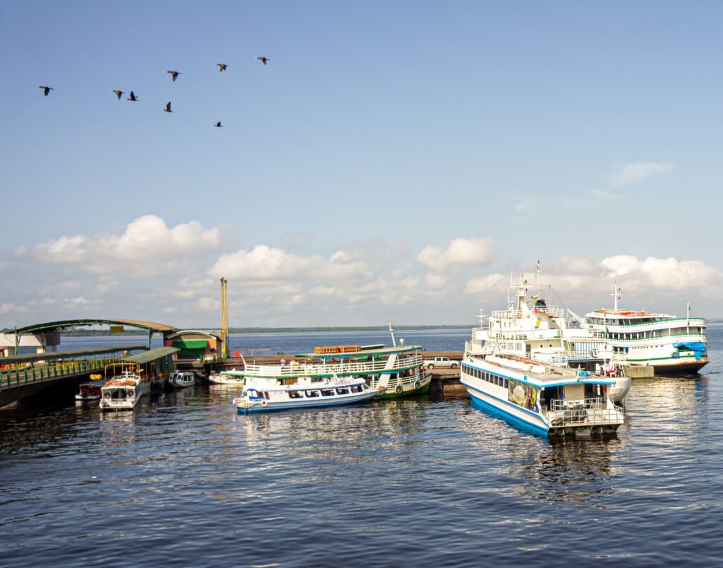 Scenic view of boats docked at a busy harbor in Manaus, Brazil with clear blue skies. viaje al amazonas colombia