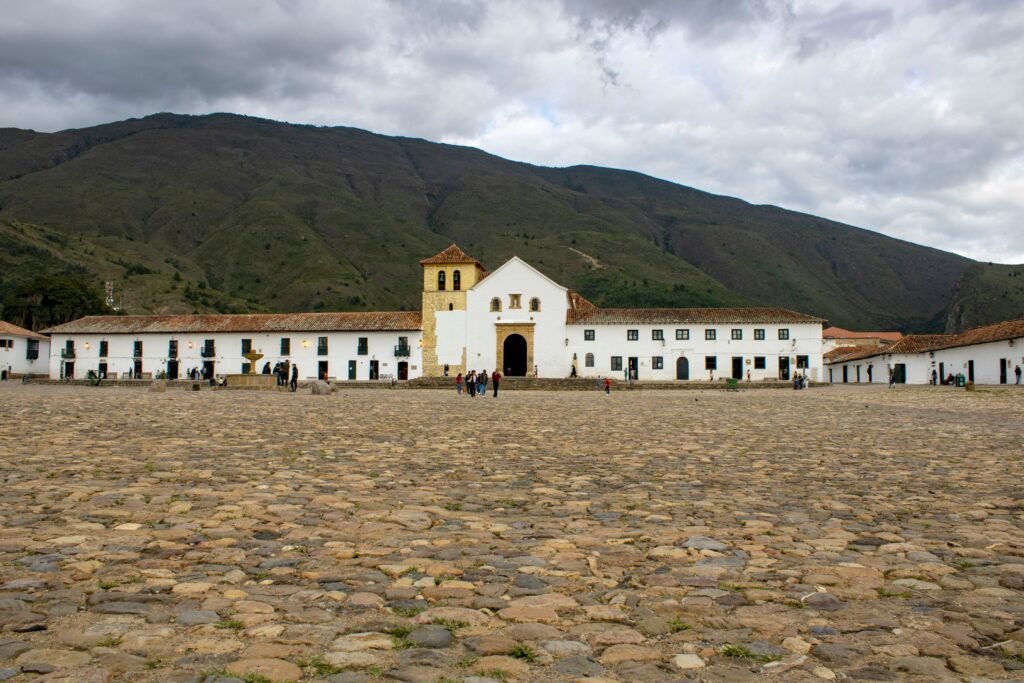 Cobblestone square of Villa de Leyva, Colombia with colonial architecture and mountain backdrop. Colombia para extranjeros