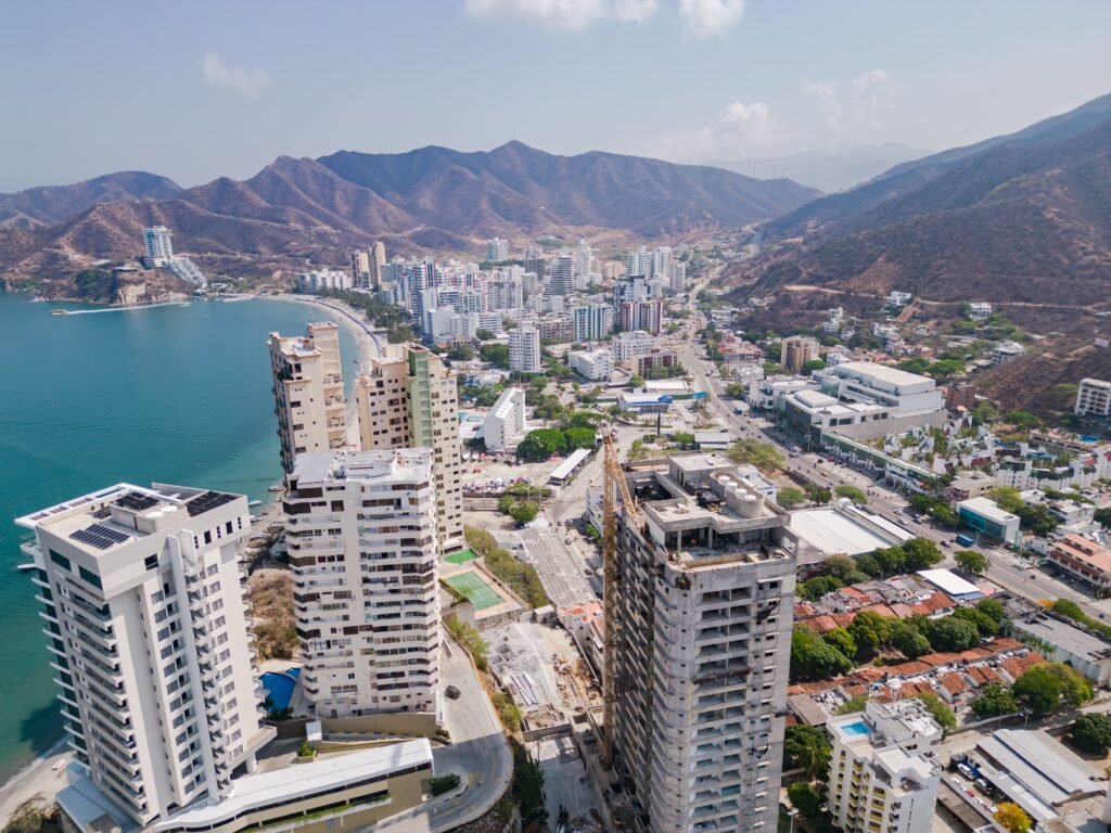 Drone shot of Santa Marta, Colombia showcasing urban skyline, coastline, and surrounding hills. paquetes santa marta todo incluido