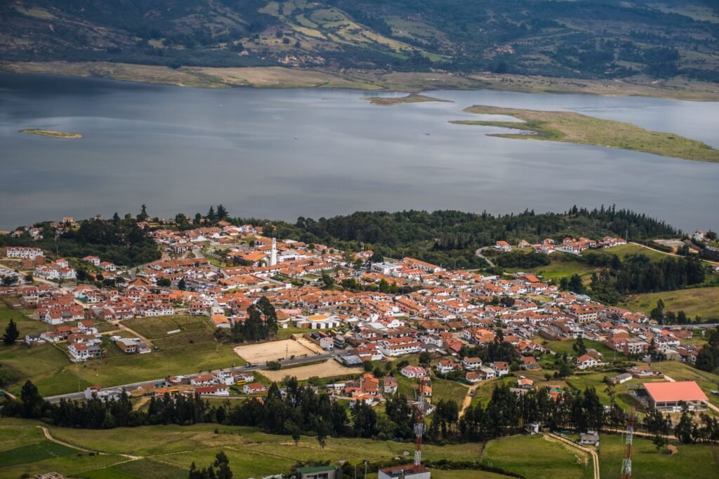 Stunning aerial view of Guatavita town and Tomine Reservoir in Colombia, showcasing a peaceful landscape. agencia de viajes online