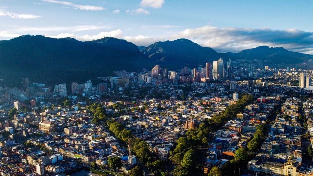 Stunning aerial photograph of Bogotá's skyline framed by lush mountains at daytime. agencia de viajes online