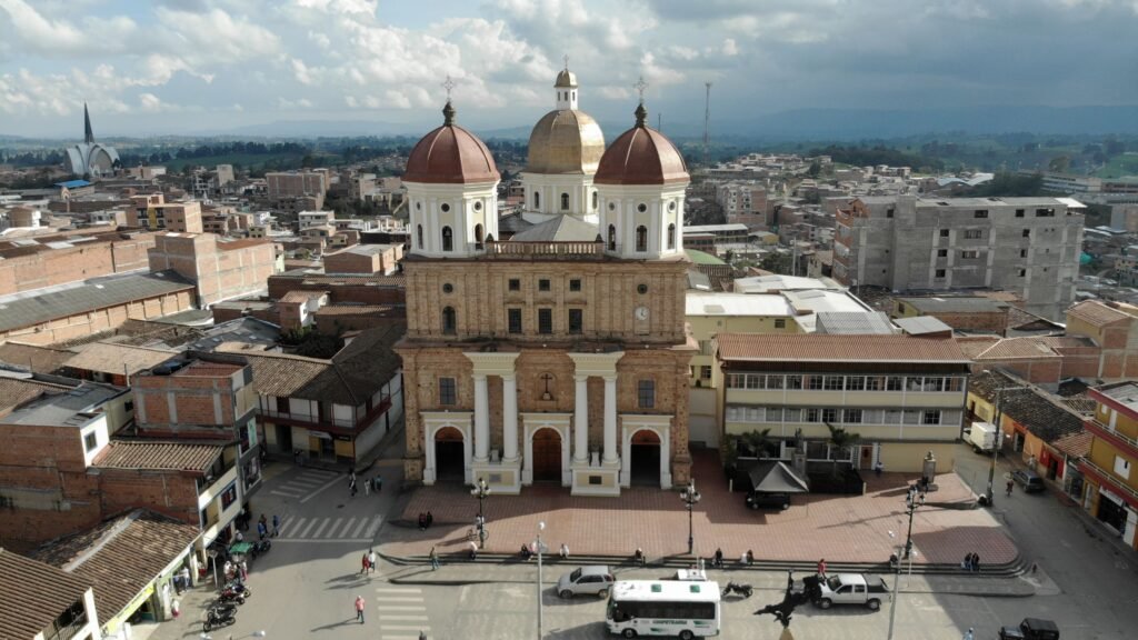 Aerial view of Carmen de Viboral's classic cathedral with scenic urban backdrop. mejor época para viajar a Colombia