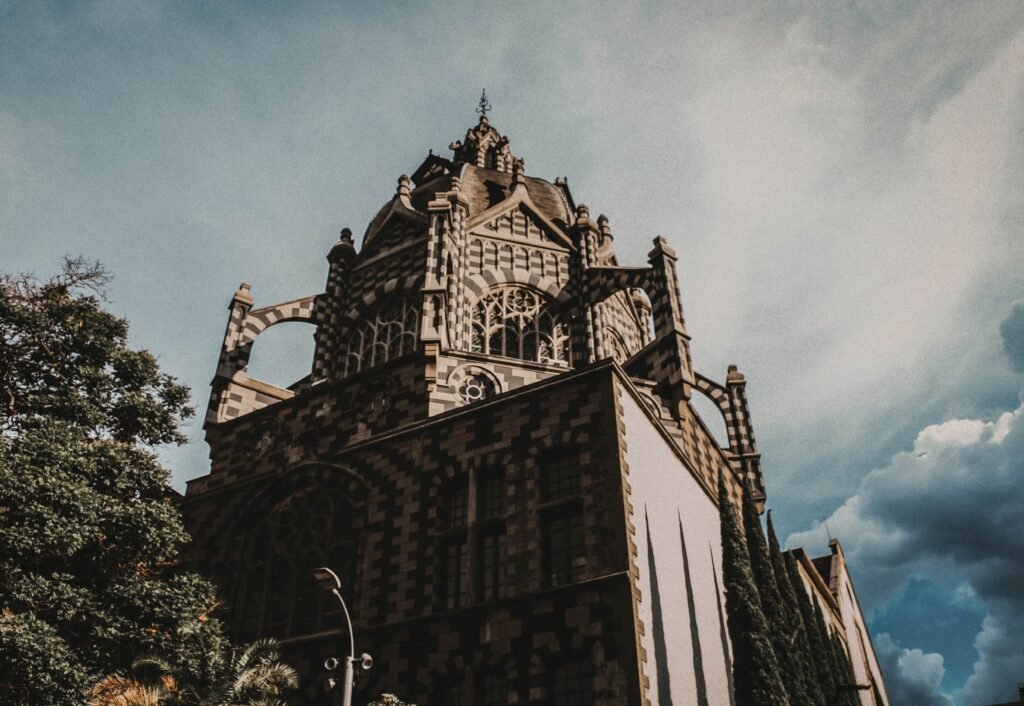 Elegant neoclassical building in Medellín showcasing intricate gothic design under the bright sky. agencia de viajes online