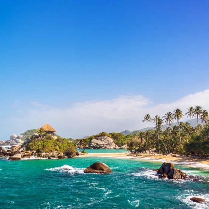 Palm trees and blue Caribbean water on the beach of San Juan del Guia in Tayrona National Park in Colombia